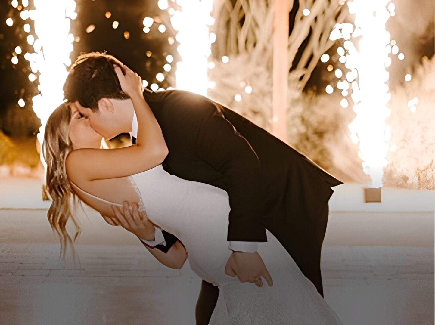 Newlyweds share romantic kiss with fireworks.
